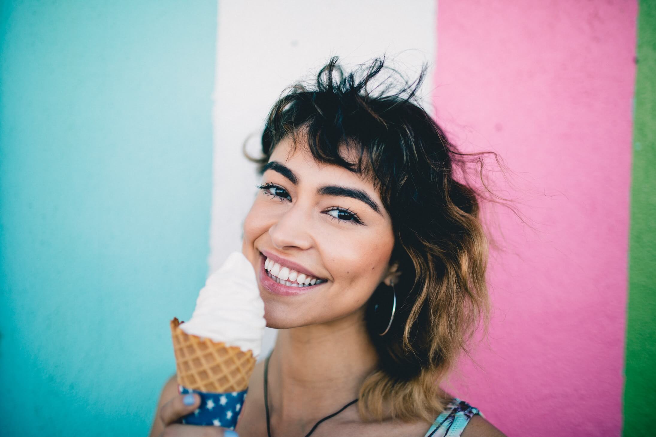 Füllbild: Frau mit Eis in der Hand, lächelt.