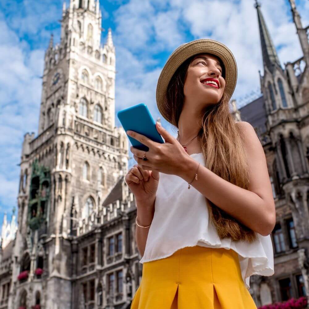 Füllbild: Frau in Sommerklamotten vor historischem Gebäude/Kirche.